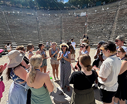 Students listening to a tour guide in an outdoor amphitheater in Greece, Summer 2024